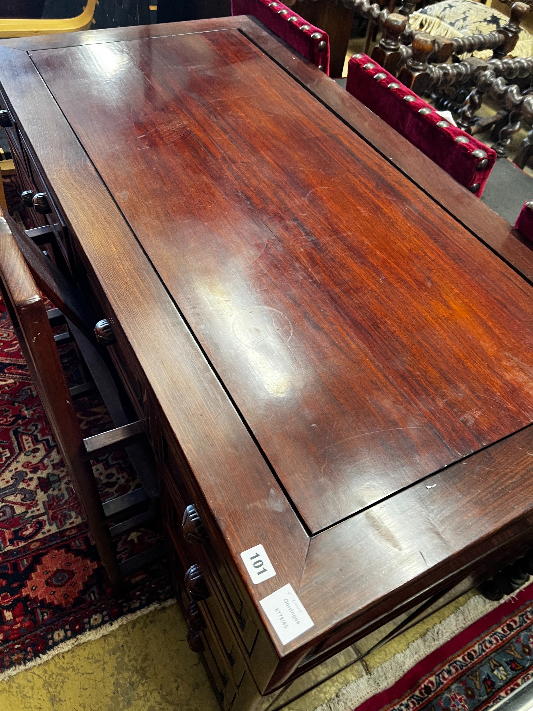 A Chinese hardwood kneehole desk, length 131cm, depth 65cm, height 83cm and elbow chair